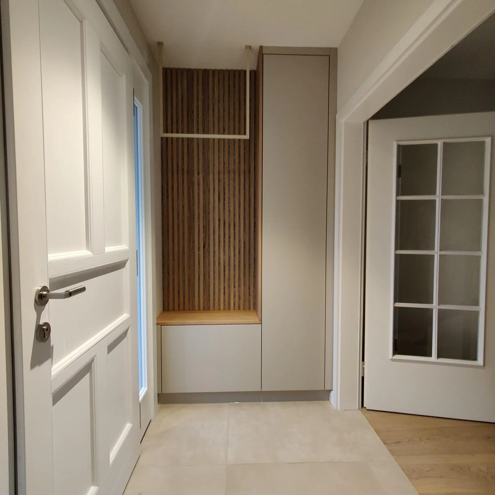 Garderobe mit Sitznische und vertikalen Lamellen im Eingangsbereich